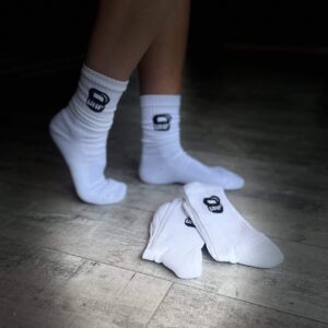 Unleashed Health and Fitness socks in white. They have a black kettle bell on the sides with UHF in white.