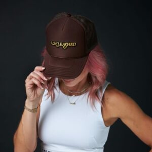 A retro Unleashed Health and Fitness branded brown trucker hat.