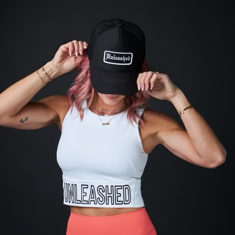 Stephanie Newcomb wearing a black Unleashed trucker hat.